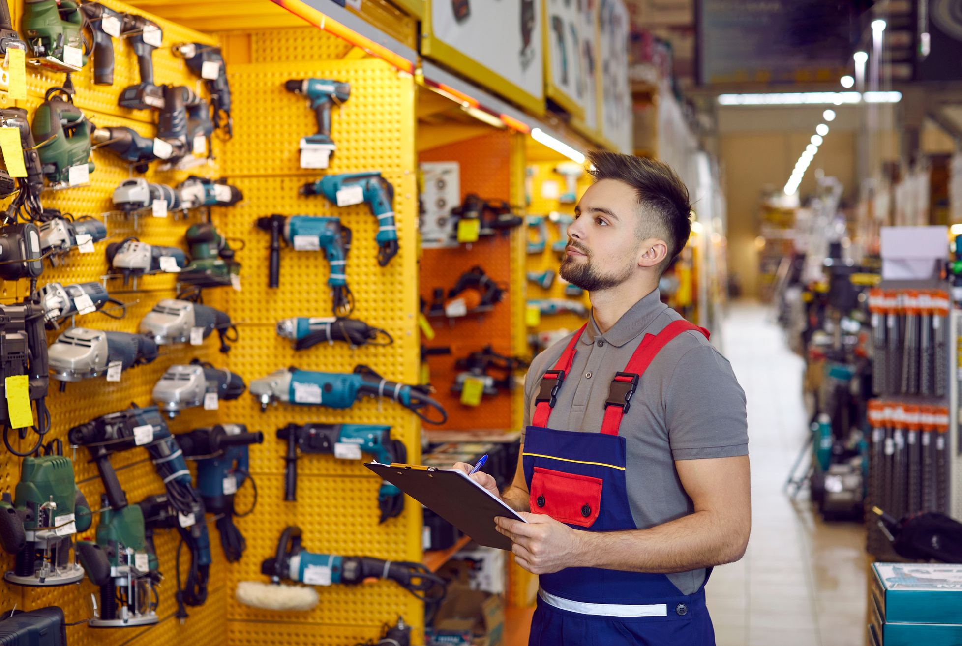 Salesman Who Works at a DIY Store or Shopping Mall Is Checking Construction Tools